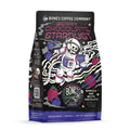 The front of a 12 ounce bag of Bones Coffee Company Berry Chocolate Stardust flavored coffee. Its flavor is berries and white chocolate. The art shows a skeleton in a spacesuit holding a cup of coffee in space on it.