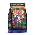 The front of a 12 ounce bag of Bones Coffee Company Nutcracker’s Revenge coffee. Its flavor is roasted chestnut, and it has a skeleton dressed as Santa running from a fire-breathing nutcracker on the art.