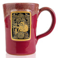 The front of the Bones Coffee Company Santa Jack hand thrown mug with Jack Skellington dressed as santa on the golden medallion. The mug is cranberry colored with a white glaze on top.