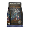 The front of a 12 ounce bag of Bones Coffee Company Army of Dark Chocolate coffee. Its flavor is dark chocolate, and it has a skeleton wielding a chainsaw standing on dark chocolate with a woman clinging to its leg on the art.