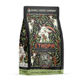 The front of a 12 ounce bag of Bones Coffee Company Ethiopia single-origin coffee. It is a light roast, and it has a goat chewing on a coffee branch with other coffee branches and goats scattered around it on the art.