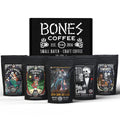 There are five four-ounce bags of coffee from Bones Coffee Company. From left to right their names are Army of Dark Chocolate, Holy Cannoli, S’morey Time, Salty Siren, and Highland Grog. A box is behind it and it features the Bones Coffee Company logo on it.