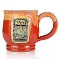 The front of the Bones Coffee Company Twin Sun Tiramisu hand thrown mug with the Twin Sun Tiramisu coffee art on the golden medallion. The mug is paprika colored with a yellow glaze on top. It is inspired by Lucasfilm’s Star Wars.