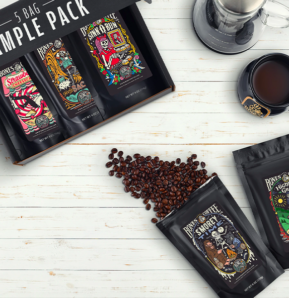 Bones Coffee Holy Cannoli bag with coffee beans, cannoli pastries, and baking ingredients on marble.